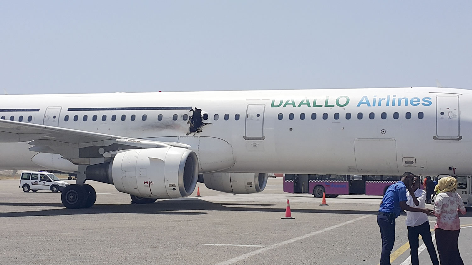 A hole is visible Tuesday in a Daallo Airlines plane as it sits on the runway at the airport in Mogadishu, Somalia.