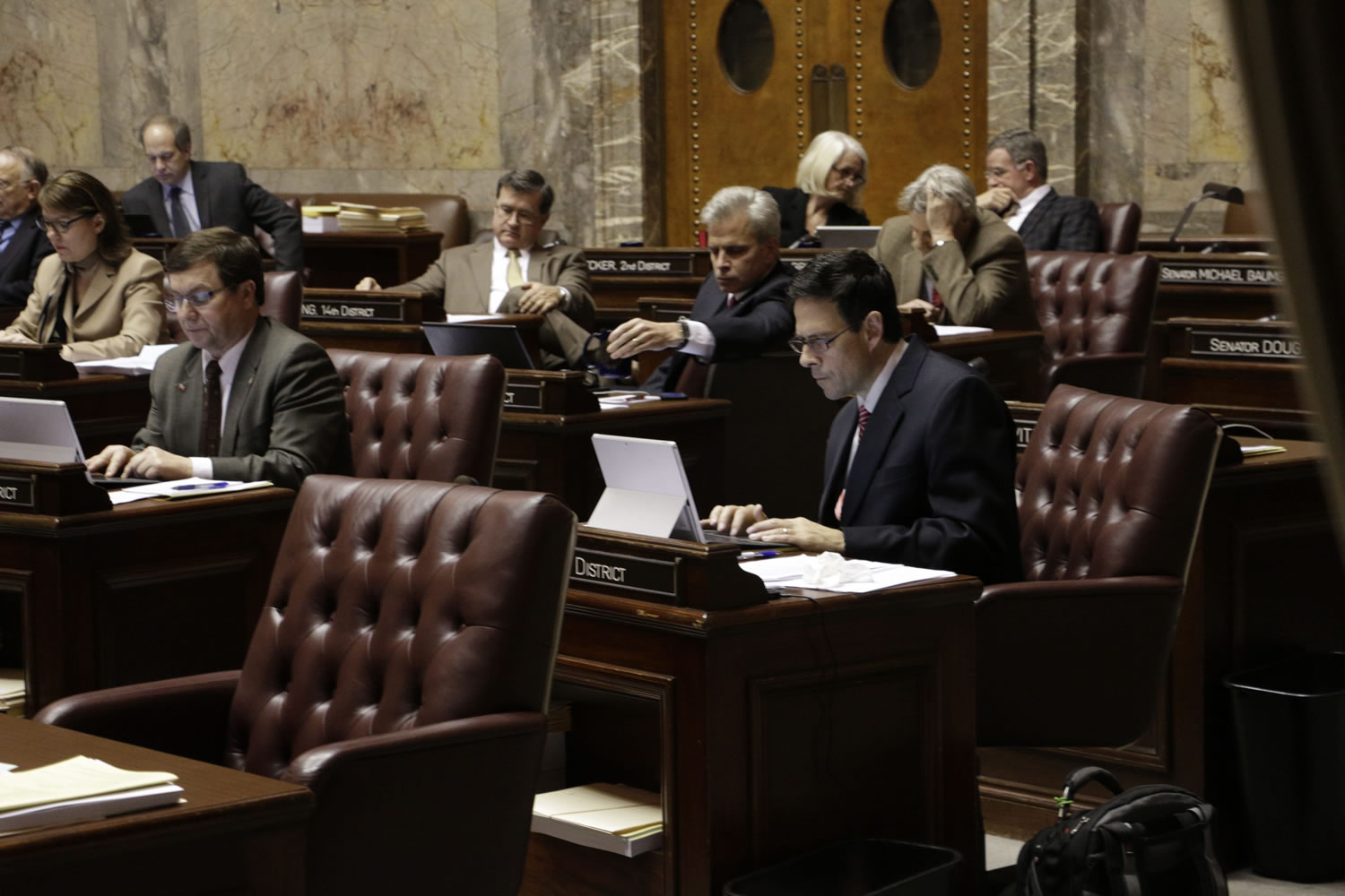 Republican Sen. Andy Hill works at his desk on the Senate floor during debate on a supplemental budget proposal Friday in Olympia. The proposal, which passed on a 25-22 vote, puts money toward repairing damage from last summer&#039;s wildfires and aiding the state&#039;s mental health system.