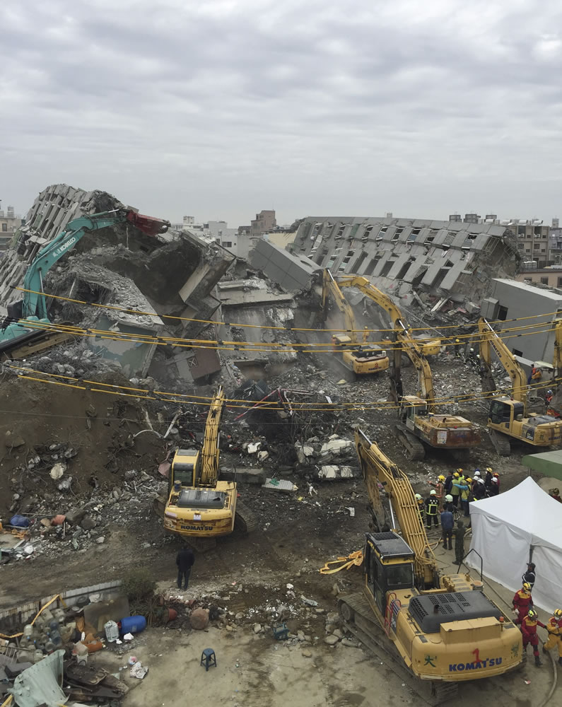 Excavators dig in the rubble of a collapsed building Wednesday in Tainan, Taiwan, as the search for survivors continues. The 17-story apartment complex was the only high-rise that toppled in Saturday&#039;s 6.4 magnitude earthquake.