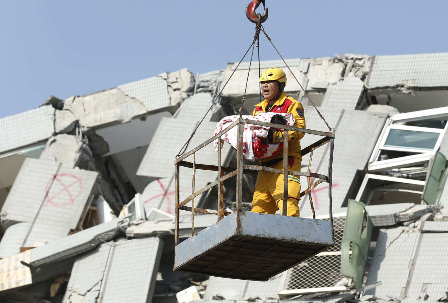 A rescuer lifts a 6-month-old girl from a collapsed building in Tainan, Taiwan, on Sunday.