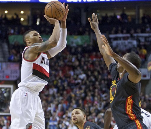 Portland Trail Blazers guard Damian Lillard, left, shoots over Golden State Warriors forward Harrison Barnes, right, during the second half of an NBA basketball game in Portland, Ore., Friday, Feb. 19, 2016.
