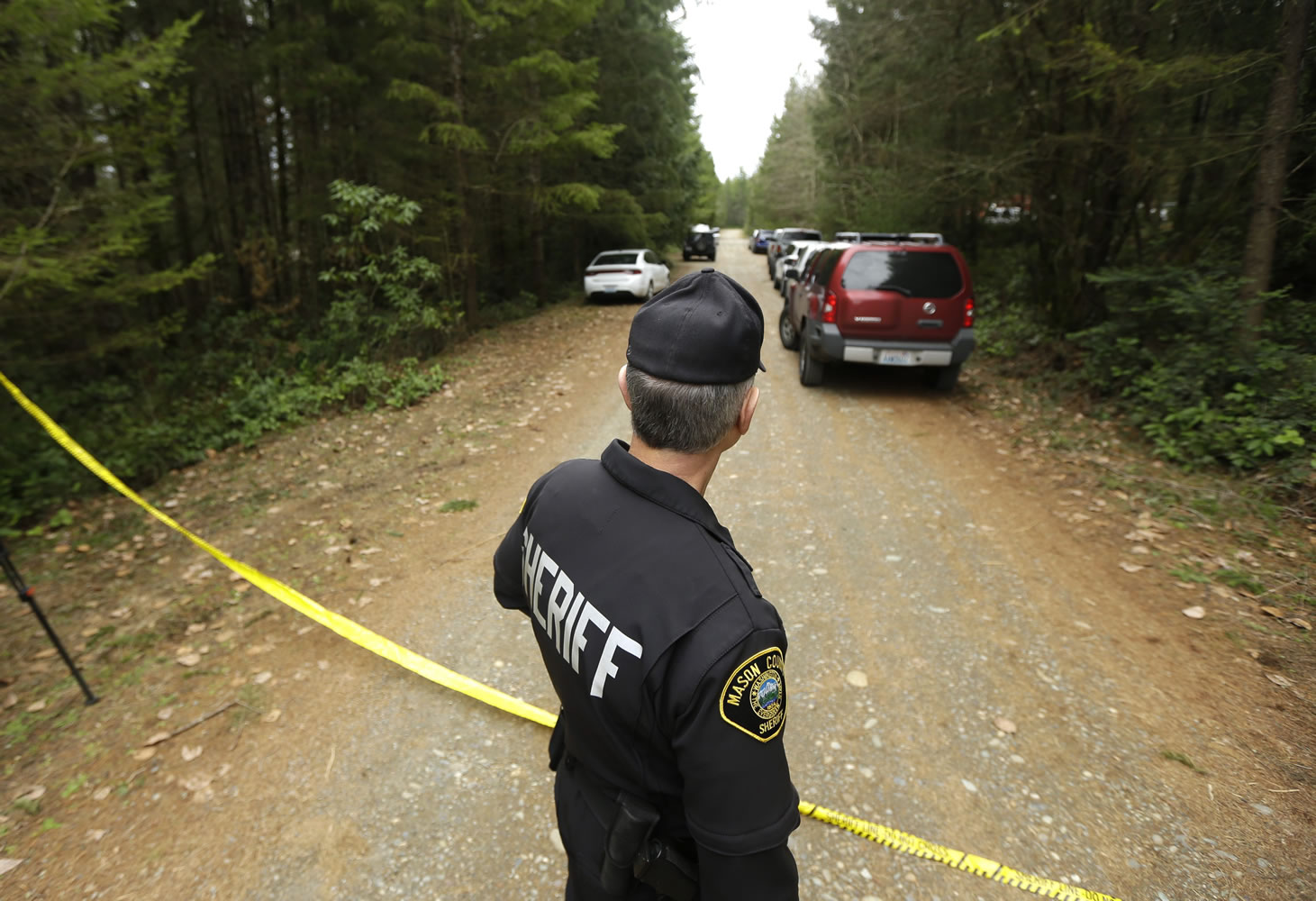 Mason County Sheriff&#039;s Chief Criminal Deputy Russ Osterhout looks down a road near the scene of a fatal shooting Friday near Belfair, about 25 miles southwest of Seattle.