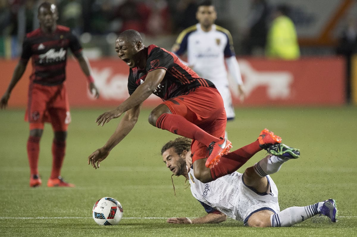 Portland Timbers forward Fanendo Adi (9) is tackled by Real Salt Lake midfielder Kyle Beckerman (5) during the first half of an MLS soccer game at Providence Park in Portland, Ore., Saturday, March 19, 2016.