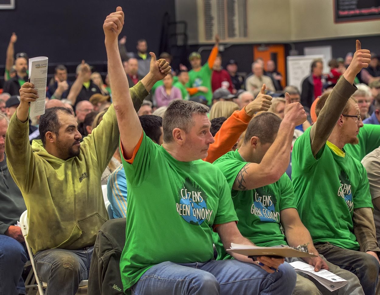 Ironworkers Kevin Joyce, center, and Edgar Condreras, left, give a thumbs up to a speaker who believes building a new methanol plant at the Port of Kalama makes good economic sense. Supporters of the project sported green shirts, while opponents wore red.