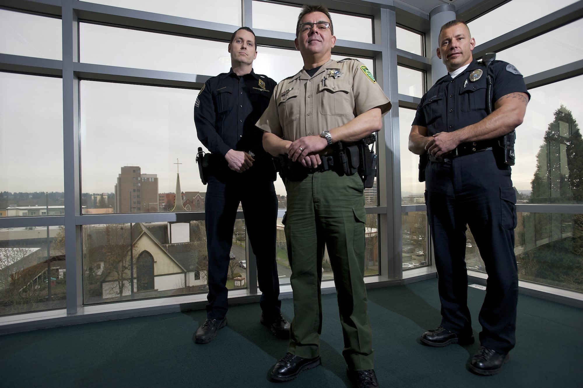 Portland Police Sgt. Peter Simpson, from left, Clark County Sheriff's Deputy Tim Hockett and Vancouver police Officer Taylor Smarr pose for a portrait inside the Clark County Public Service Center in February 2013. The Vancouver Police Department, Clark County Sheriff's Office and Portland Police Bureau had just announced plans to use one central records management system that would allow officers to easily access information from other agencies. The sheriff's office is now saying the system isn't worth the hassle.