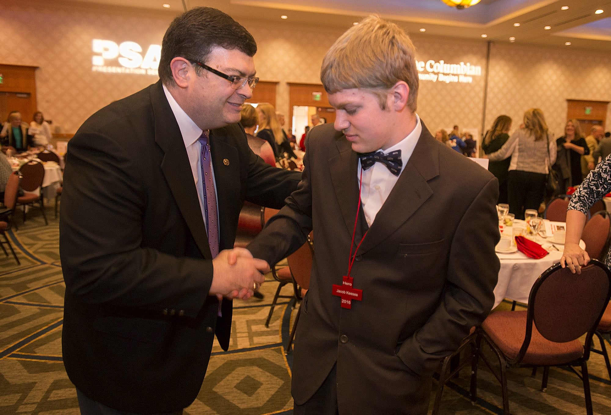 Dan Clark, senior vice president for Banner Bank, left, congratulates Jacob Keesee after he received the emergency response hero award at the 19th annual Real Heroes Breakfast on Friday morning at the Vancouver Hilton.