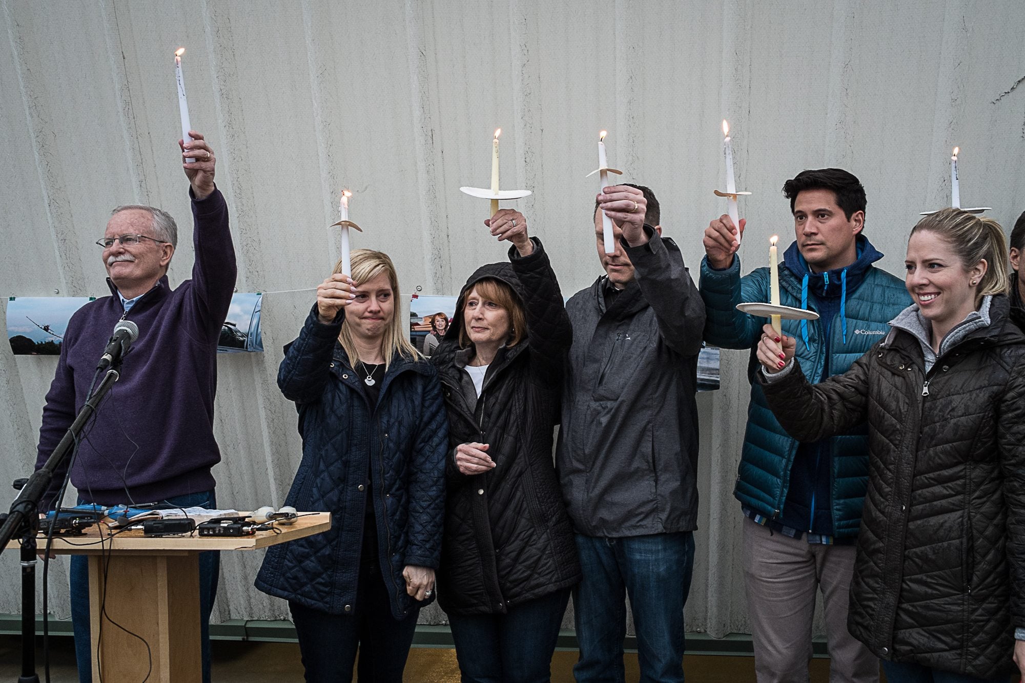 John McKibbin's family and the Rev. Fitz Neal, left, hold up candles in remembrance of McKibbin's life at a vigil Saturday evening at Pearson Field in Vancouver.
