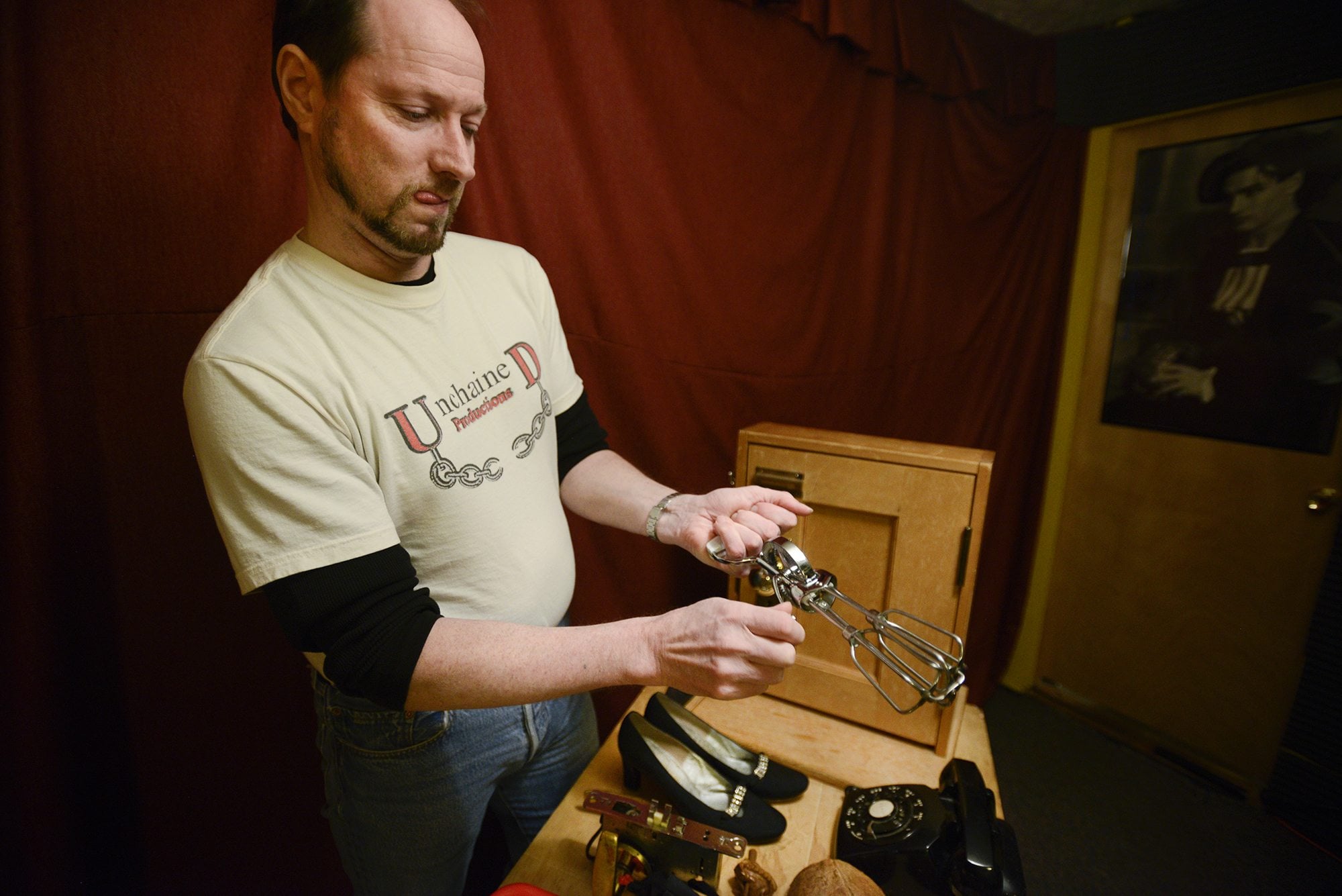Foley artist David Ian reproduces the sound of spinning wagon wheels with an eggbeater.  Ian uses a variety of unique props to create live sound effects for the Willamette Radio Workshop.