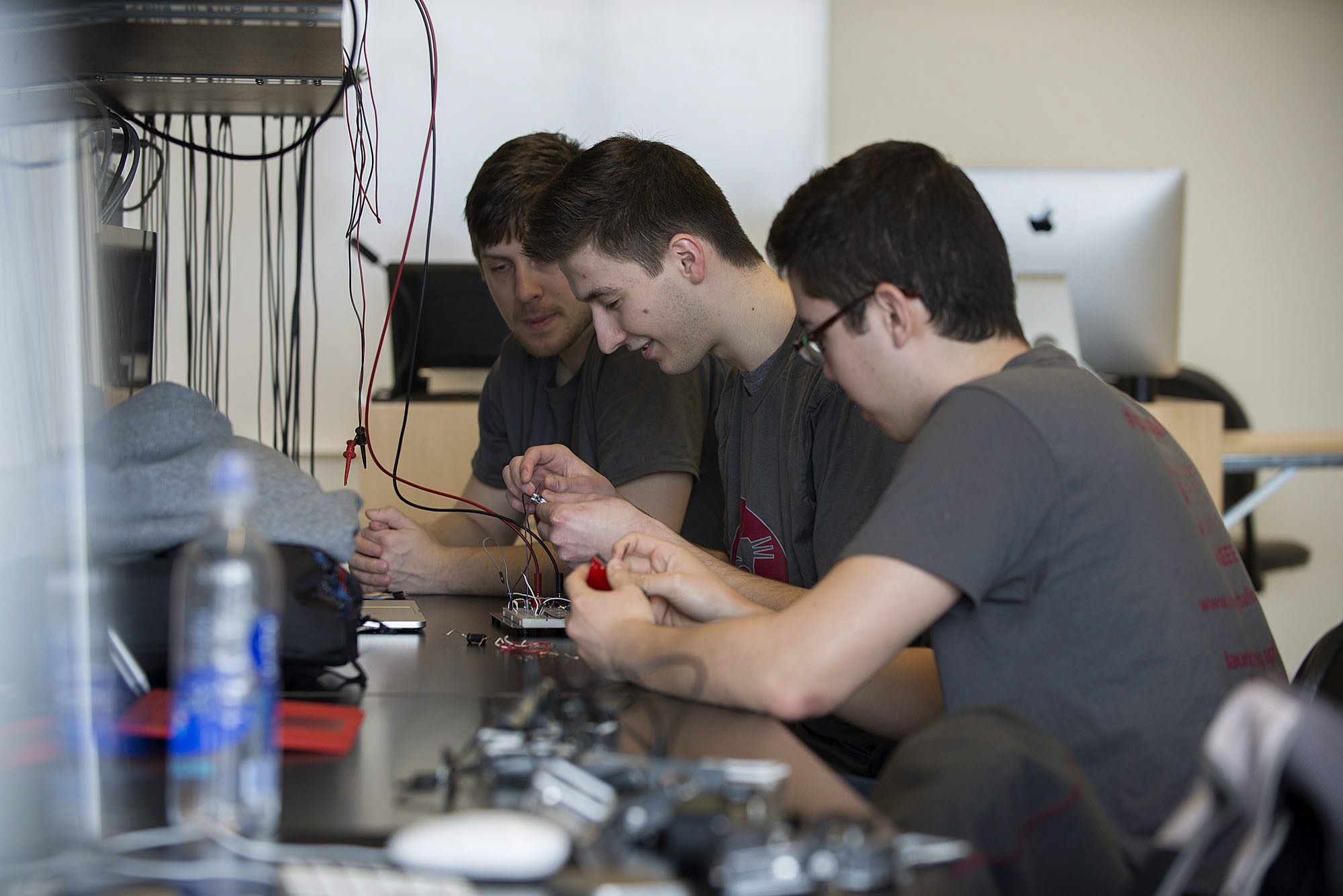 Juniors Cody Henderson, from left, Raoul Russ and Mitchell Russum work on circuitry for an ozone sensor Friday at Washington State University Vancouver.