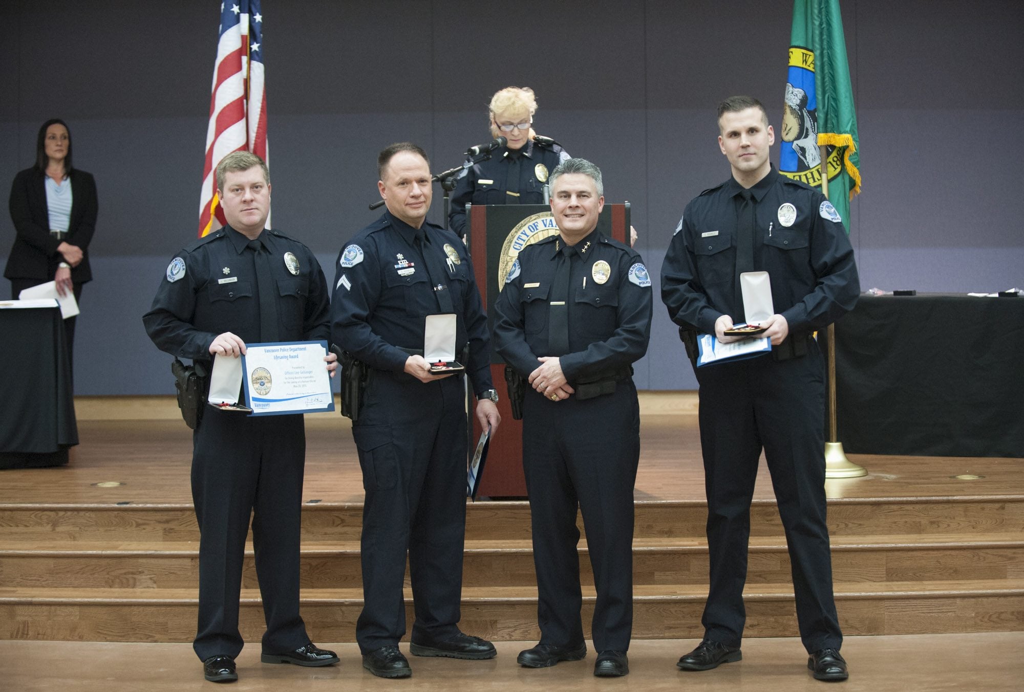 Officer Lee Gelsinger, from left, receives the Vancouver Police Department&#039;s Lifesaving Award on Tuesday night from Chief James McElvain; Cpl. Drue Russell and Officer Christopher Douville also received the award.