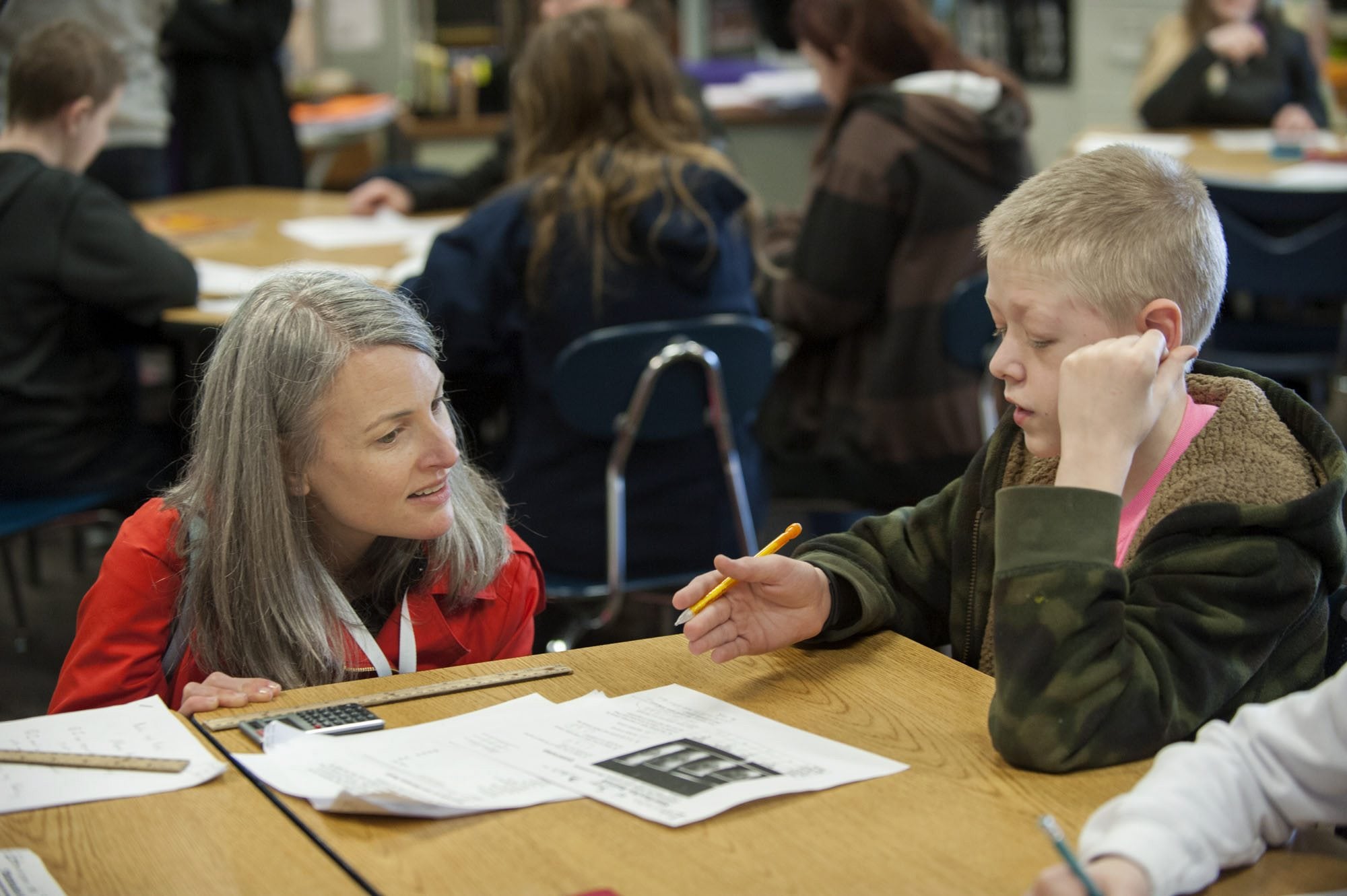 Caroline King, left, chief policy officer for Washington STEM, chats with sixth-grader Hayden Kahler, 11, about calculating the ratios of caffeine to sugar in coffee drinks during his math class Wednesday at Frontier Middle School.