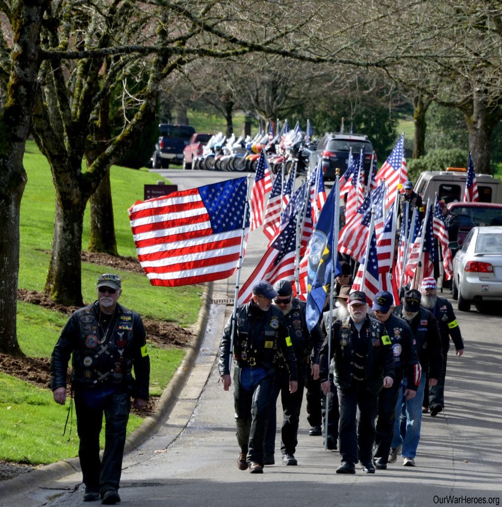Hazel Dell: Members of Patriot National Guard honor two unclaimed soldiers by holding American flags during funeral procession.
