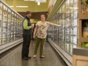 Vancouver New Seasons Market manager Glen Jones, left, and the store&#039;s Green Team captain Makayla Karlsen look over energy-saving doors at the store, which was recognized Thursday evening by the Clark County Green Business Program as the Green Business of the Year.