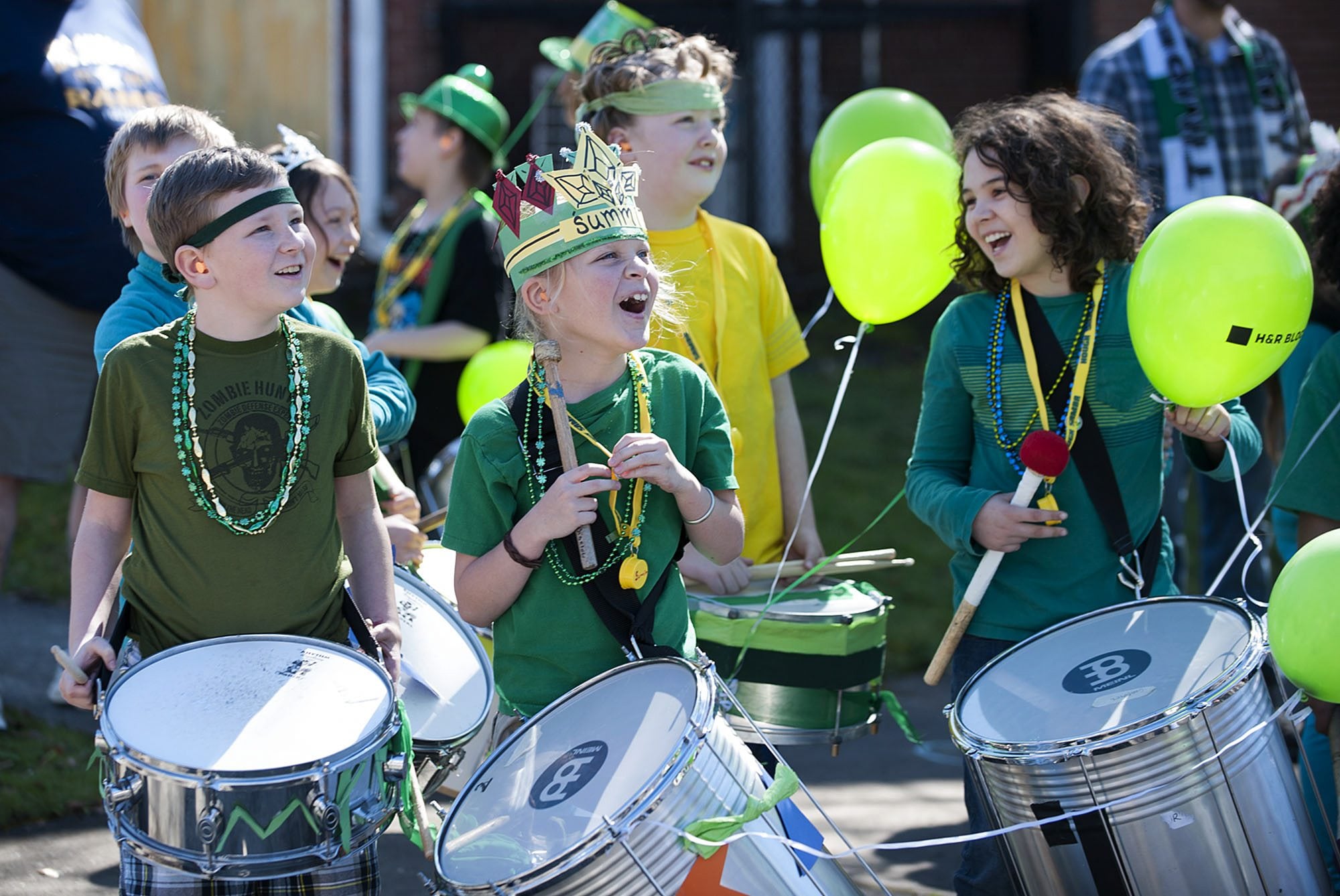 Hough Elementary School fourth-graders Spencer Smith, 9, left, and Summit Joling, 10, second from left, share a moment of joy behind the scenes with classmates as they wait for the 25th annual Paddy Hough Parade to begin Thursday in the Hough neighborhood.