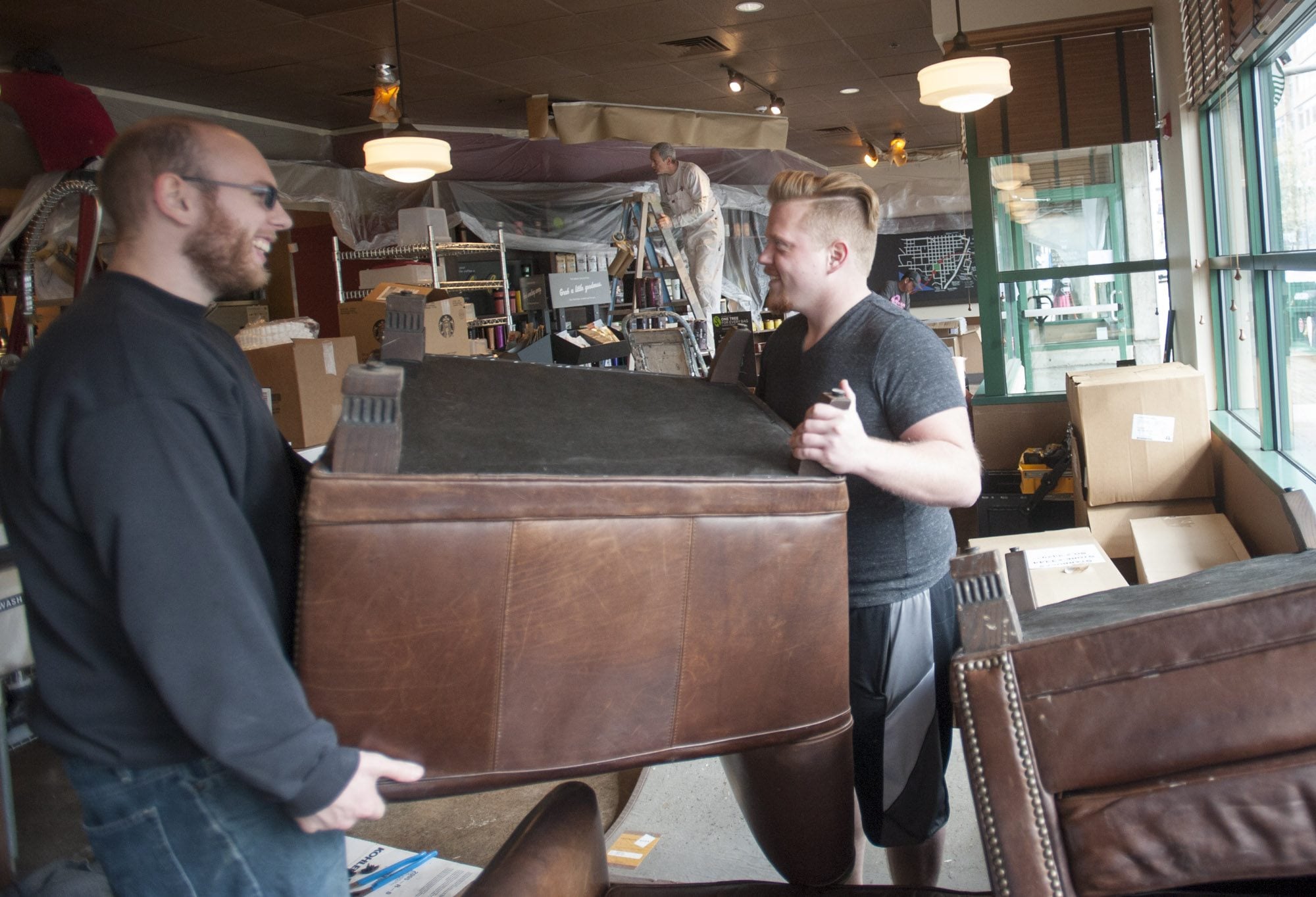 Steven Morgan, right, moves furniture with Wyatt McGehee as remodeling takes place at the Starbucks near Esther Short Park in Vancouver on Monday.