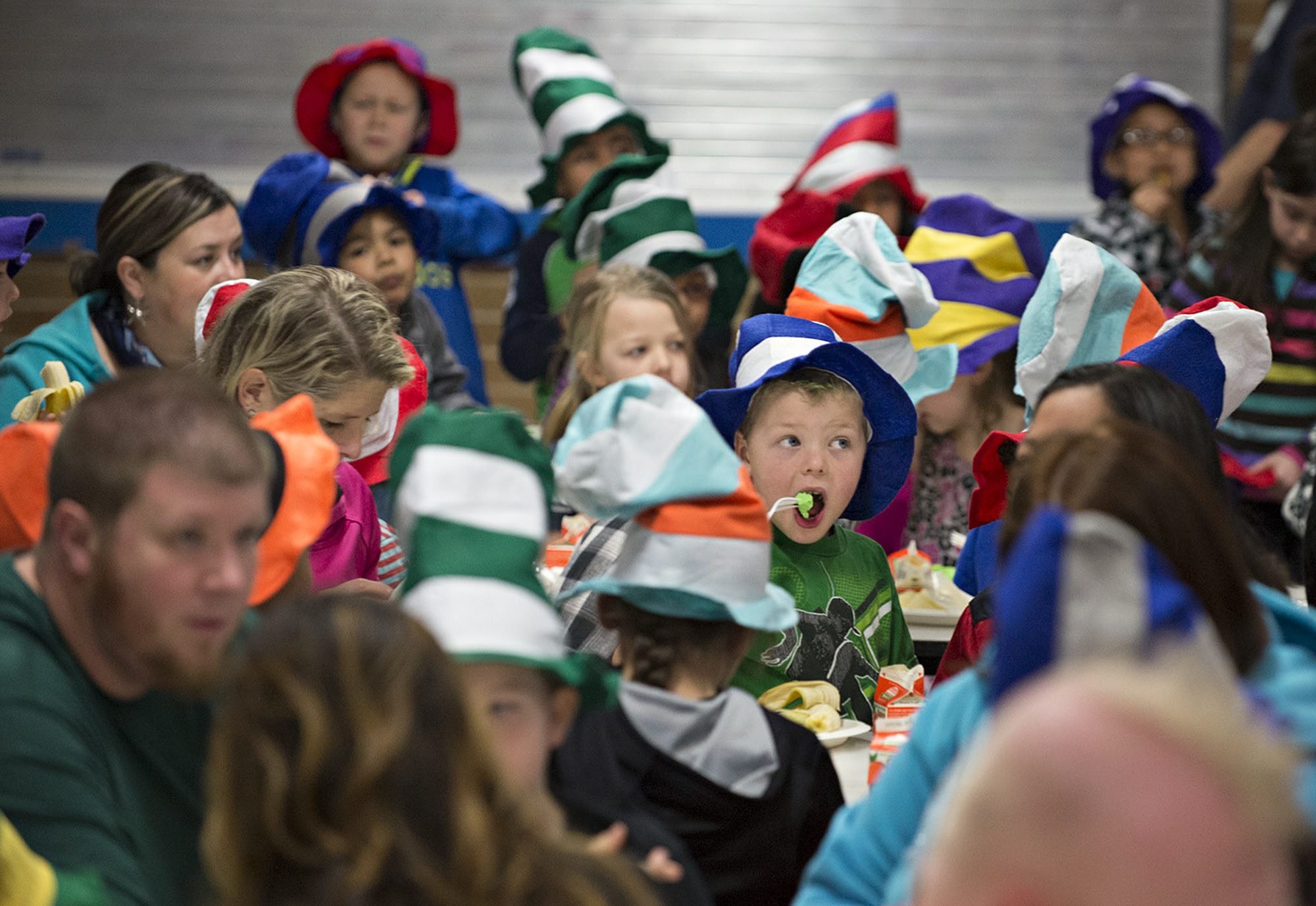 First-grader Jordan Terry, wearing green shirt and holding fork, is surrounded by a sea of Dr. Seuss hats as he eats his green eggs and ham Tuesday morning at Ellsworth Elementary School.