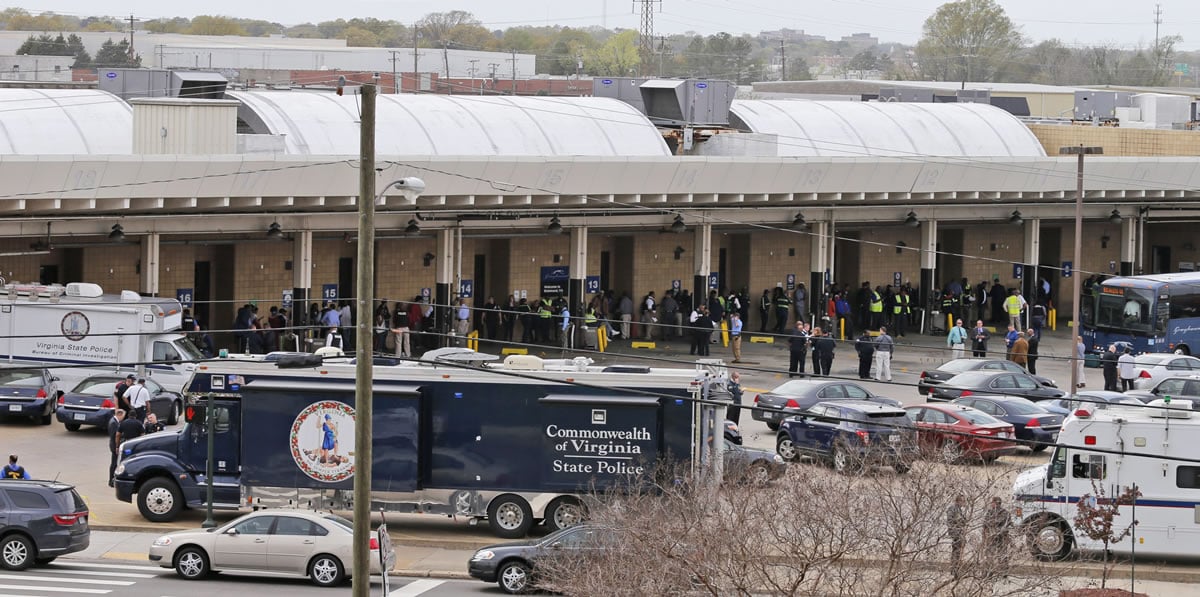 Police and rescue officials mingle with bus patrons outside the Greyhound Bus Station Thursday, March 31, 2016, in Richmond, Va. Virginia State Police say two troopers responding to a shooting at the Richmond bus station and a civilian have been taken to a hospital. A police spokeswoman says the shooting suspect was in custody.