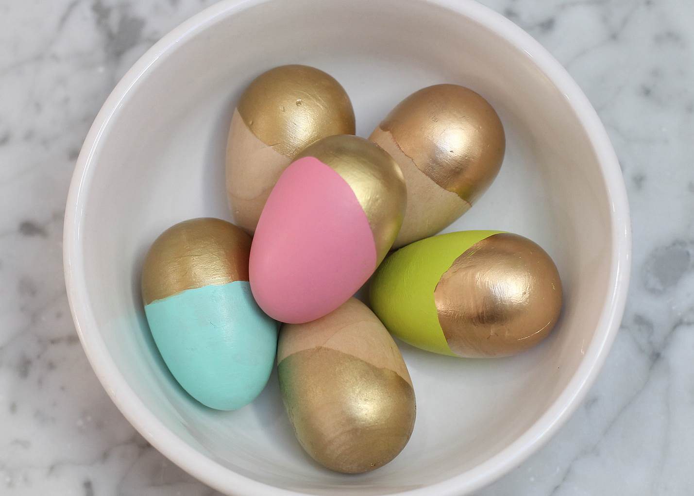 Wooden eggs that combine two fashion and decorating trends -- color-blocking and gold-dipping -- are arranged in a bowl for an easy Easter display. The Associated Press tested three techniques and found they varied slightly in cost, ease of execution and results.