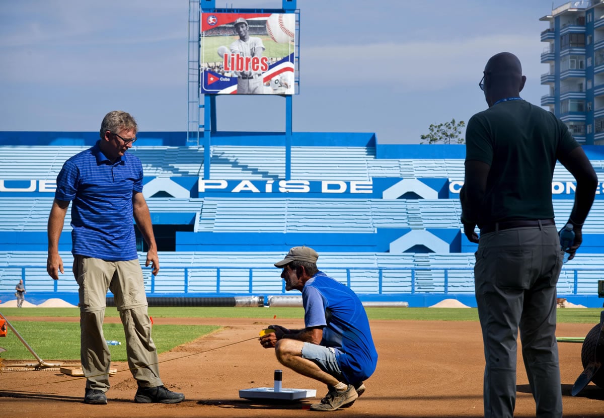 Murray Cook, left, and Phil Bradley, right, from the Major League Baseball Players Association talk to a worker during the refurbishing of the Latinoamericano stadium where a friendly game will be played on March 22 between the Cuban national baseball team and the Tampa Bay Rays, in Havana, Cuba, on Wednesday.