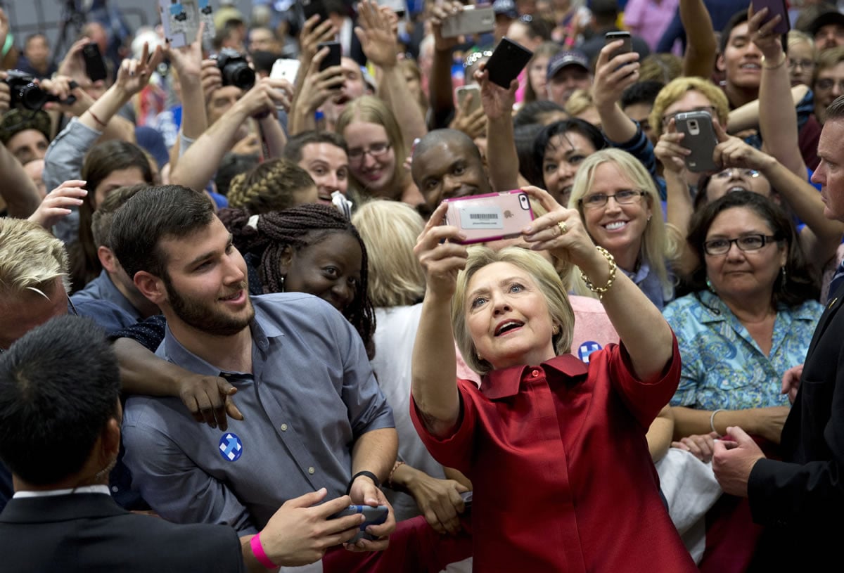 Democratic presidential candidate Hillary Clinton takes photos with supporters in the audience after speaking during a campaign event at Carl Hayden Community High School in Phoenix on Monday.
