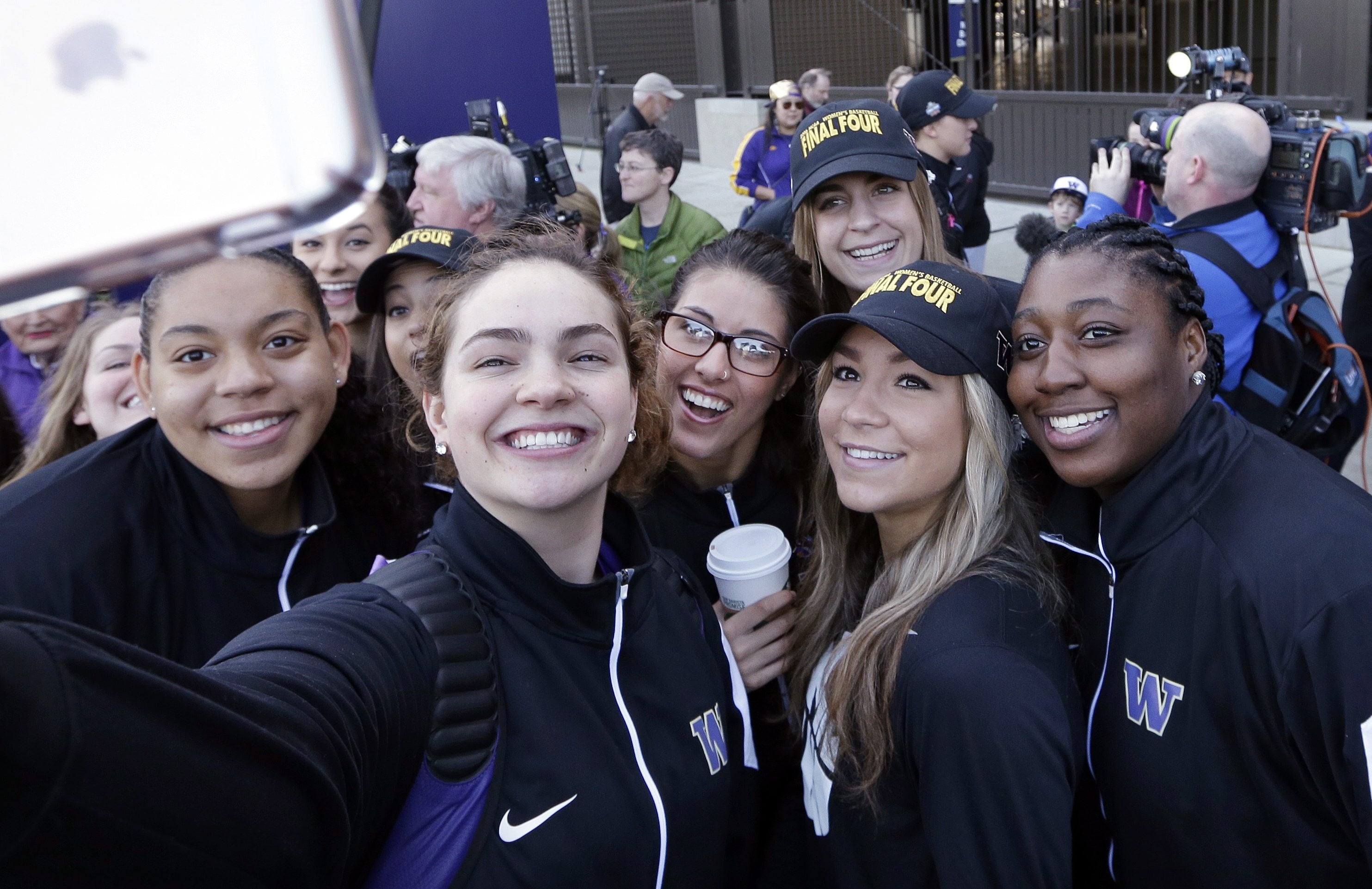 Washington players huddle together for a selfie during a sendoff rally for the Washington women&#039;s basketball team. The Huskies play Syracuse in a national semifinal on Sunday. Prairie graduate Heather Corral is seen in the center, wearing glasses.