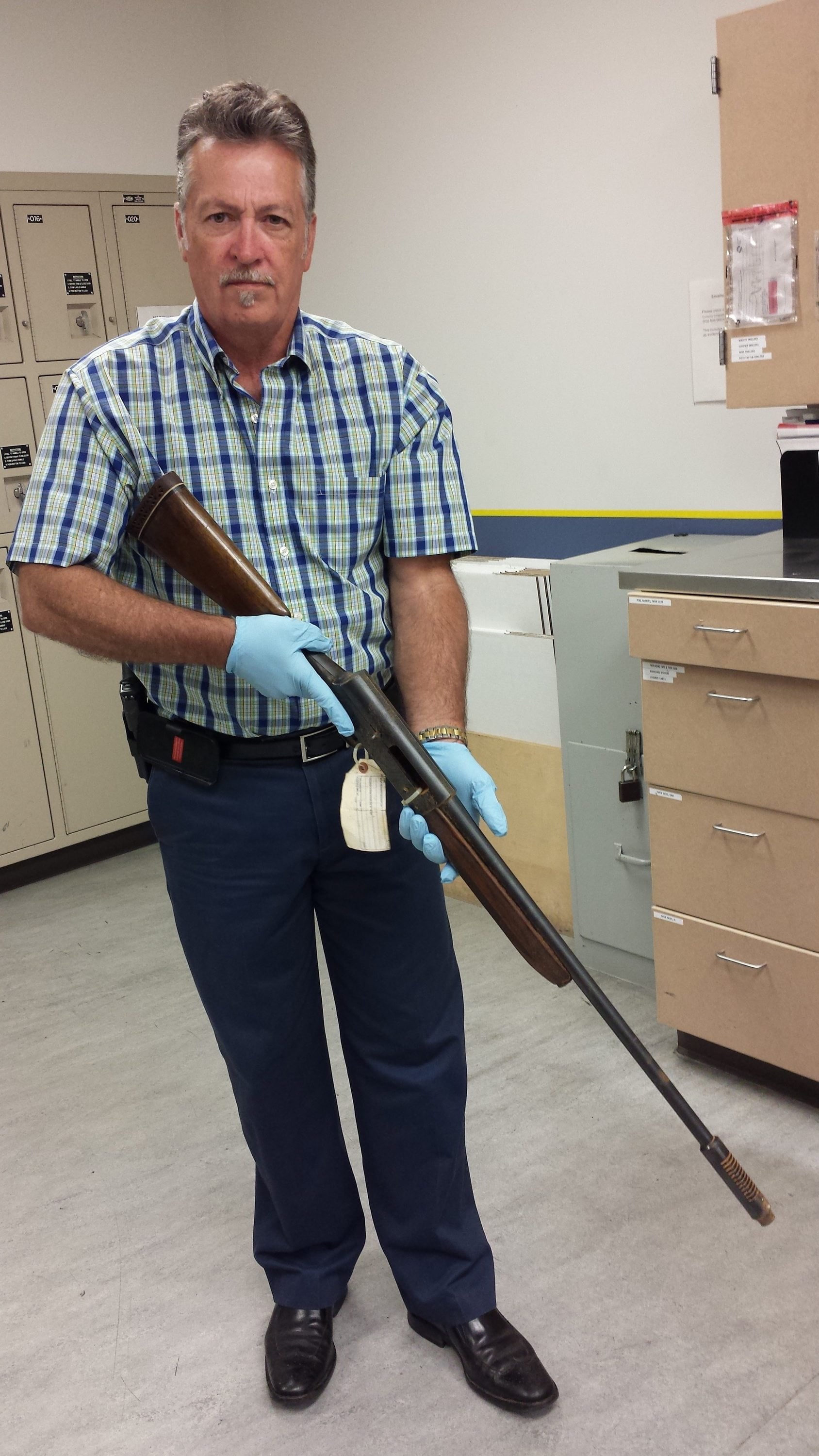 In this June 2015 photo released by the Seattle Police on Thursday, Detective Michael Ciesynski holds the shotgun which rock legend Kurt Cobain used to kill himself on April 8, 1994. Police did not say why they took the photos last year or why they&#039;re releasing them to the public at this time.