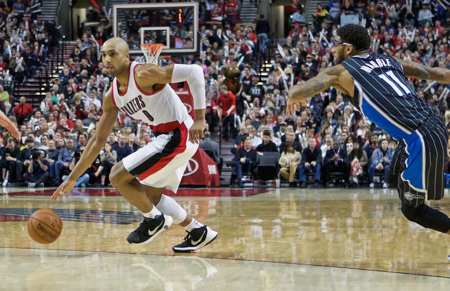 Portland Trail Blazers guard Gerald Henderson, left, dribbles past Orlando Magic forward Devyn Marble, right, during the second half of an NBA basketball game in Portland, Ore., Saturday, March 12, 2016.