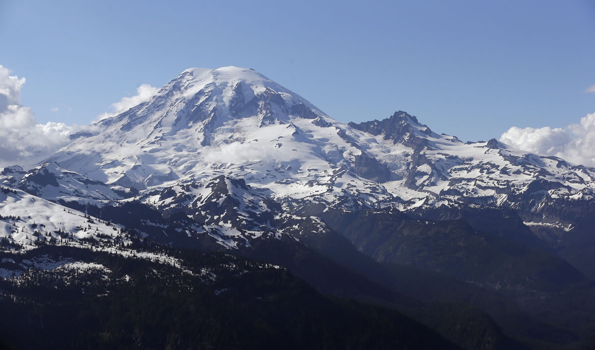 Mount Rainier is seen from a helicopter flying south of the mountain and west of Yakima on June 19, 2013. One climber has likely died from hypothermia and exposure on Mount Rainier after he and his climbing partner were caught in a winter storm over the weekend, a spokeswoman with Mount Rainier National Park said. A Chinook helicopter crew and other rescue teams were working Monday to reach the 58-year-old man from Norway.