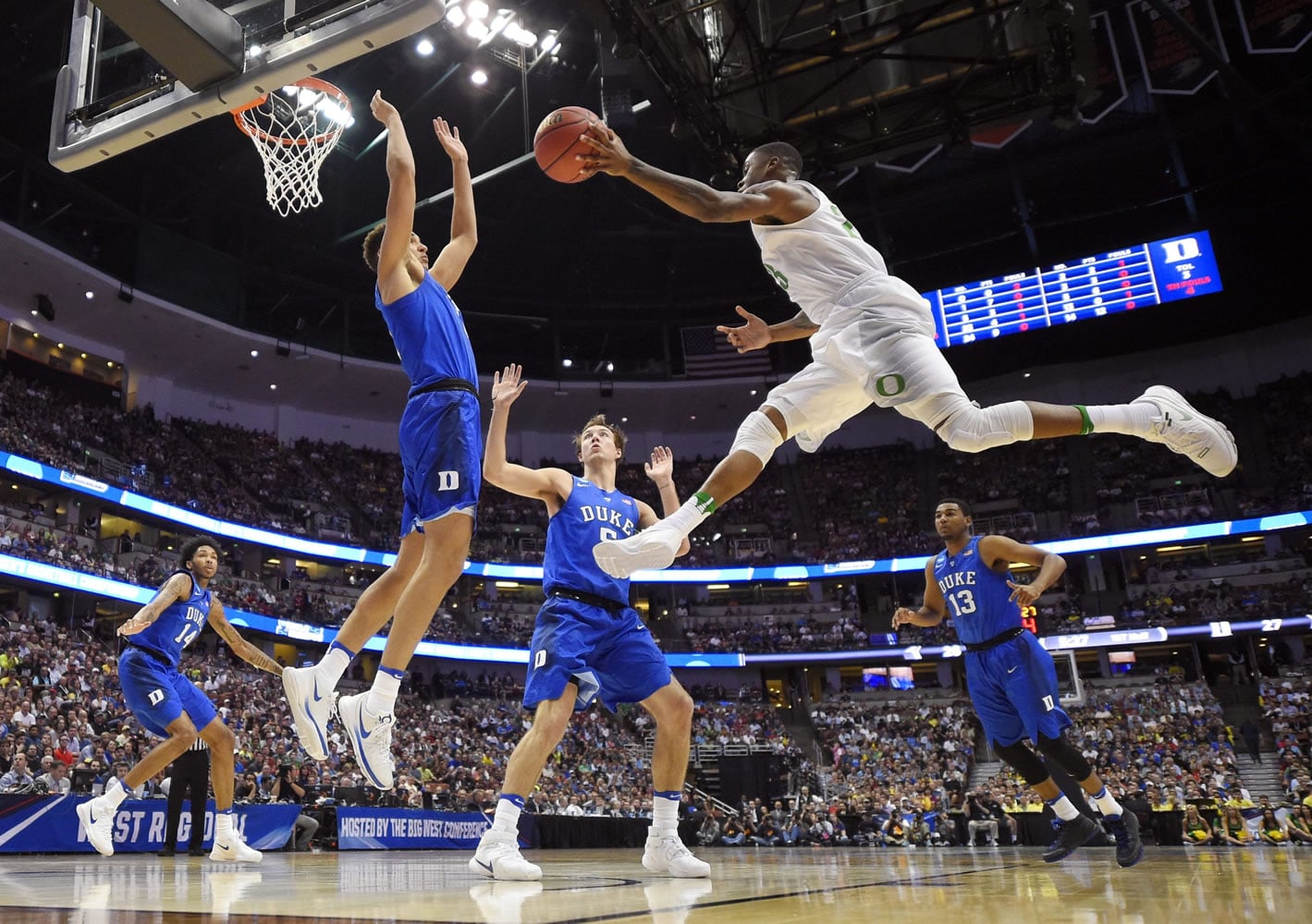 Oregon's Elgin Cook passes the ball as Duke forward Chase Jeter defends during the first half of an NCAA college basketball game in the regional semifinals of the NCAA Tournament, Thursday, March 24, 2016, in Anaheim, Calif. (AP Photo/Mark J.