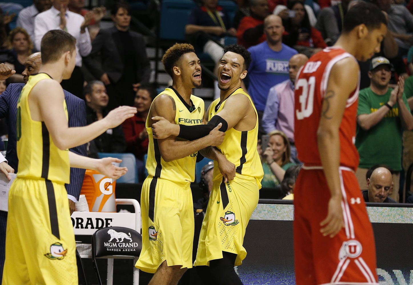 Oregon guard Tyler Dorsey, center left, embraces forward Dillon Brooks as they celebrate after Oregon defeated Utah in an NCAA college basketball game in the championship of the Pac-12 men's tournament Saturday, March 12, 2016, in Las Vegas. Oregon won 88-57.