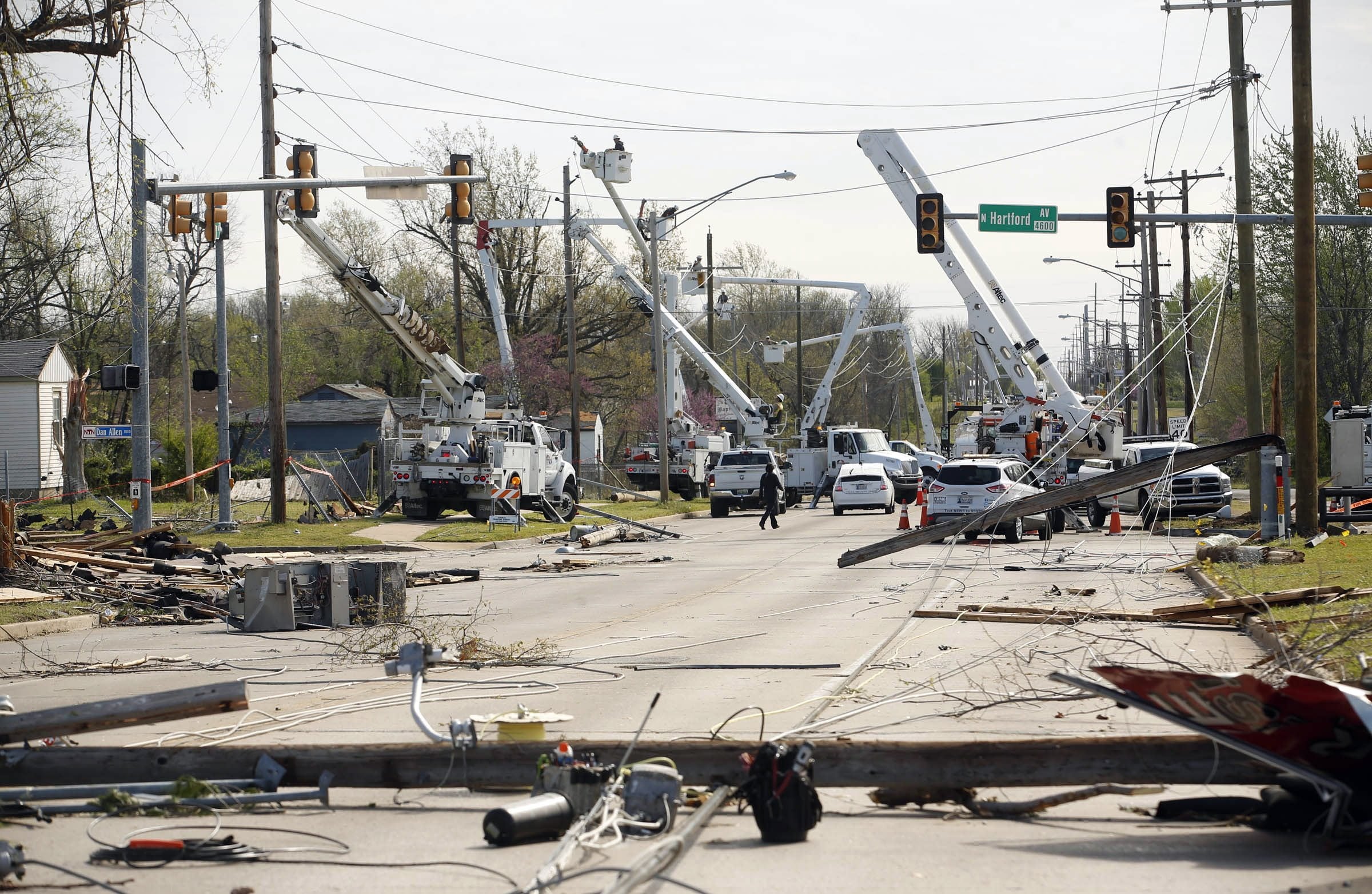 Utility crews work to fix broken power lines and poles Thursday in Tulsa, Okla., after a tornado moved through the area Wednesday night.
