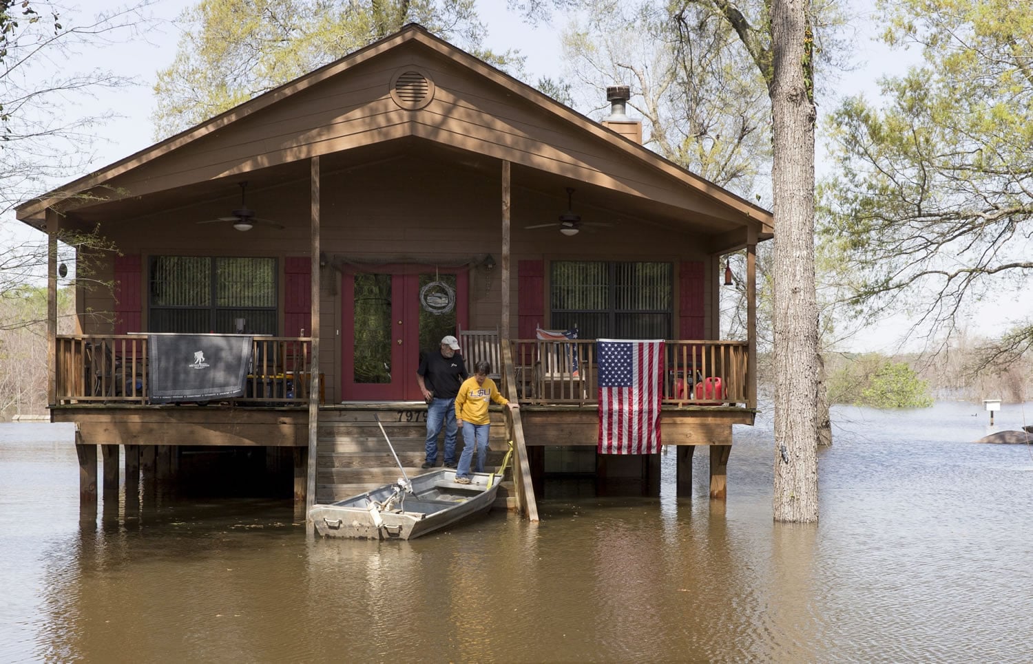 Residents make their way to a boat Sunday as water from Caddo Lake surrounds the raised house in Mooringsport, La. President Barack Obama has signed an order declaring Louisiana&#039;s widespread flooding from heavy rains a major disaster.