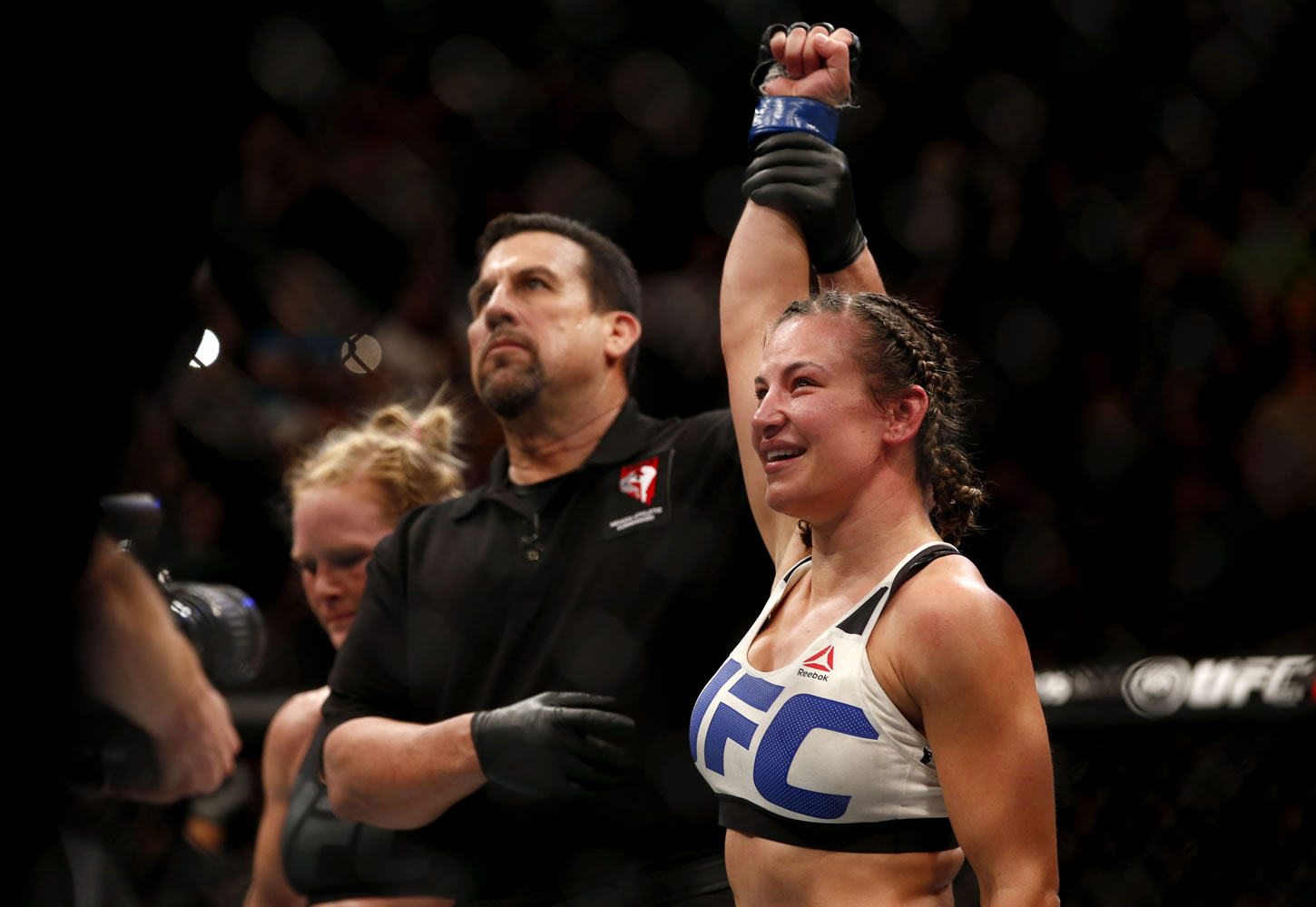 Tacoma's Miesha Tate, right, celebrates victory over Holly Holm during their UFC 196 women's bantamweight mixed martial arts match, Saturday, March 5, 2016, in Las Vegas.