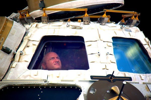 In this undated photo provided by NASA on Tuesday, March 1, 2016, astronaut Scott Kelly looks out the cupola of the International Space Station. Kelly closes the door Tuesday to an unprecedented year in space for NASA, flying back to the planet and loved ones he left behind last March.