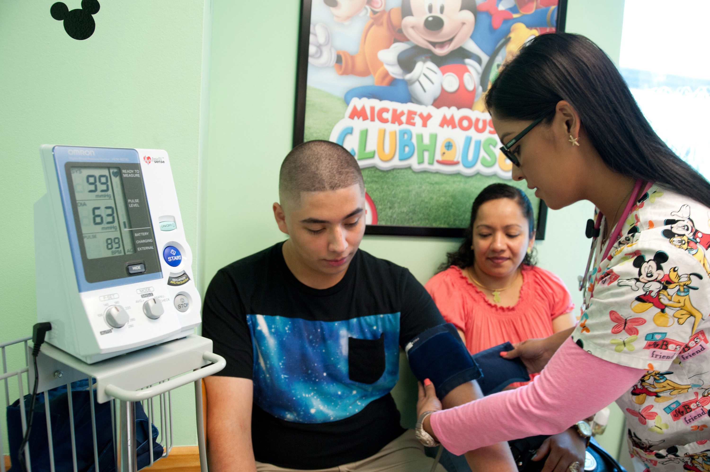 Jose Amaya, 14, gets his blood pressure measured by medical assistant Gisselle Nogueira, as his mother, Sandra Amaya, looks on at Nicklaus Children&#039;s Hospital in Coral Terrace, Fla.