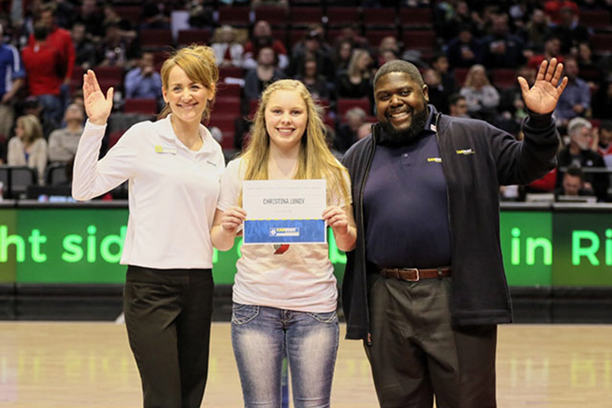 Mountain View: Christina Lundy, center, pictured with two CarMax employees, was honored at a recent Blazers game after being named a CarMax Teen Captain.