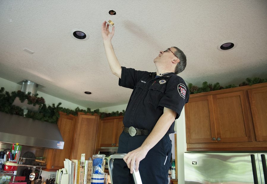 Camas-Washougal Fire Department Deputy Fire Marshal Randy Miller exposes a home sprinkler unit in the kitchen of his house.