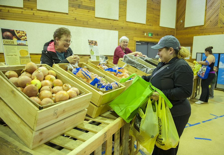 Volunteer Linda Luke, left, assists Martha Aguayo of Vancouver as she shops for produce at a Food Bank Fresh stand set up at St. John Lutheran Church in Hazel Dell.