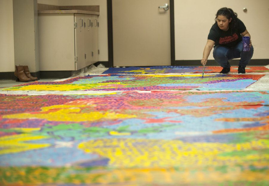 Fort Vancouver High School student Michelle Garcia, a member of the school&#039;s MEChA Club, works on a mural Monday that will be hung at the Vancouver Police Department&#039;s West Precinct building.