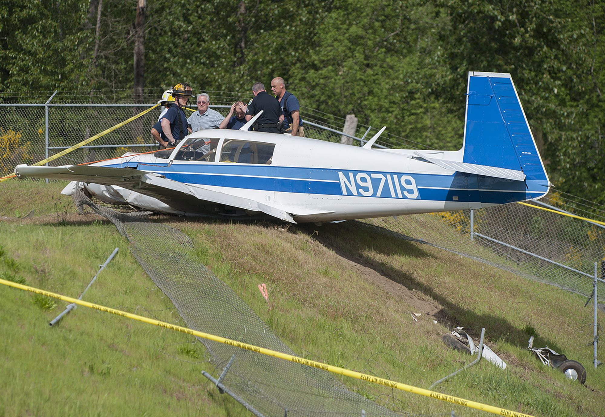 Officials and firefighters look over the wreckage after a small plane crashed Thursday afternoon, April 21, 2016 at Woodland Airport.