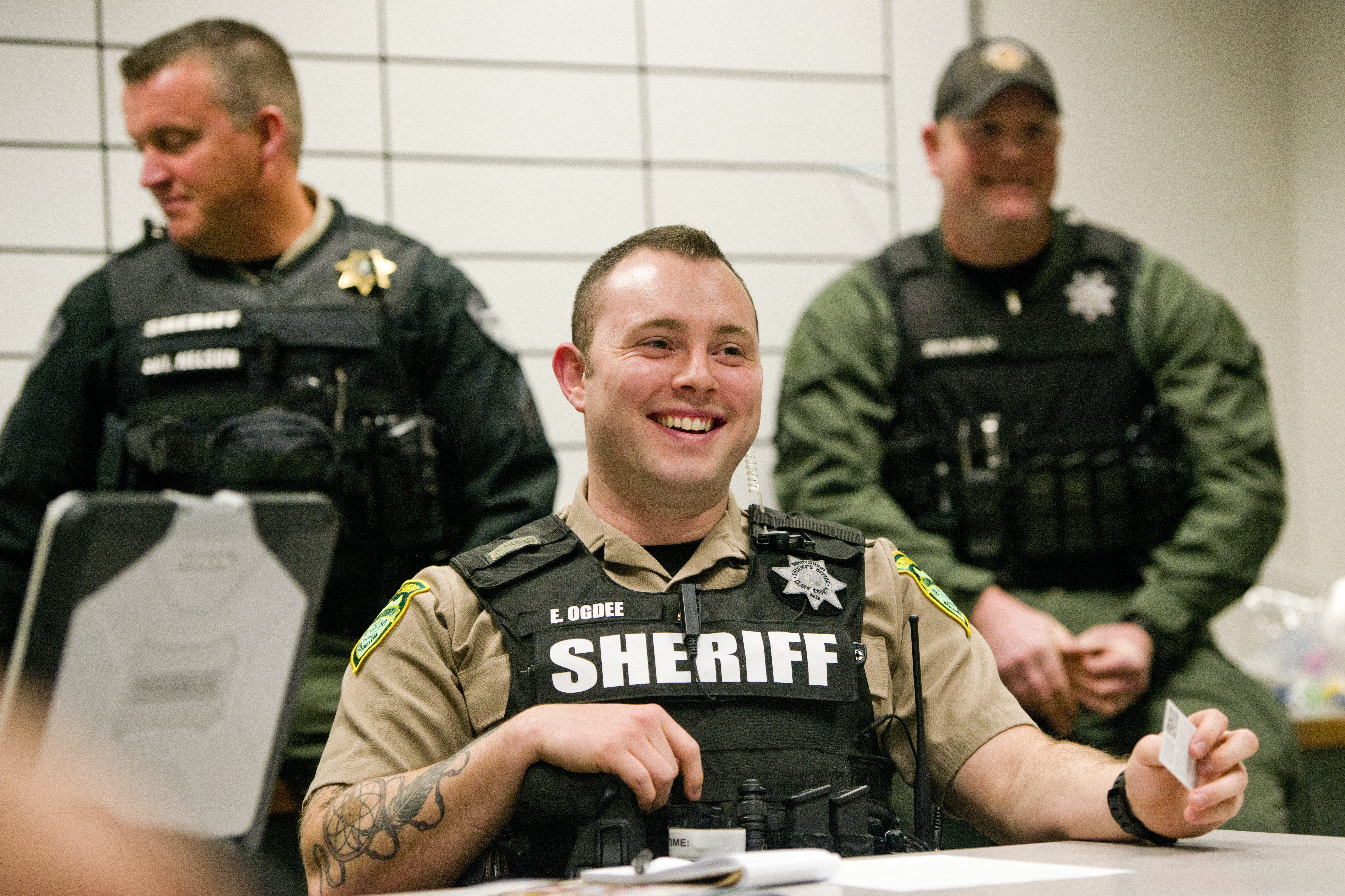 New Clark County Sheriff’s Deputy Ethan Ogdee, center, listens during a briefing before his graveyard shift. It took Ogdee more than a year to get hired, which isn’t atypical. While local agencies like the sheriff’s office are looking to ramp up their numbers, one of the things working against them is the lengthy hiring process.