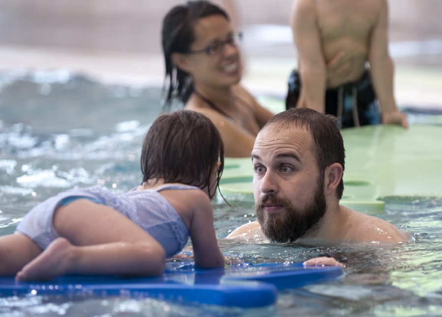 Curtis Hale swims with his 2-year-old daughter, Livia, at the Firstenburg Community Center pool Saturday. A number of families filled the center on a day of free admission and activities. Louise Allen of Vancouver Parks and Recreation called the facility an &quot;all-purpose&quot; space for the entire community.