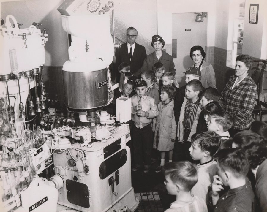 Harold Corwin, top left, a second-generation owner of Corwin Beverage, leads a group of children on a tour of the company&#039;s Vancouver production facility in the 1950s.