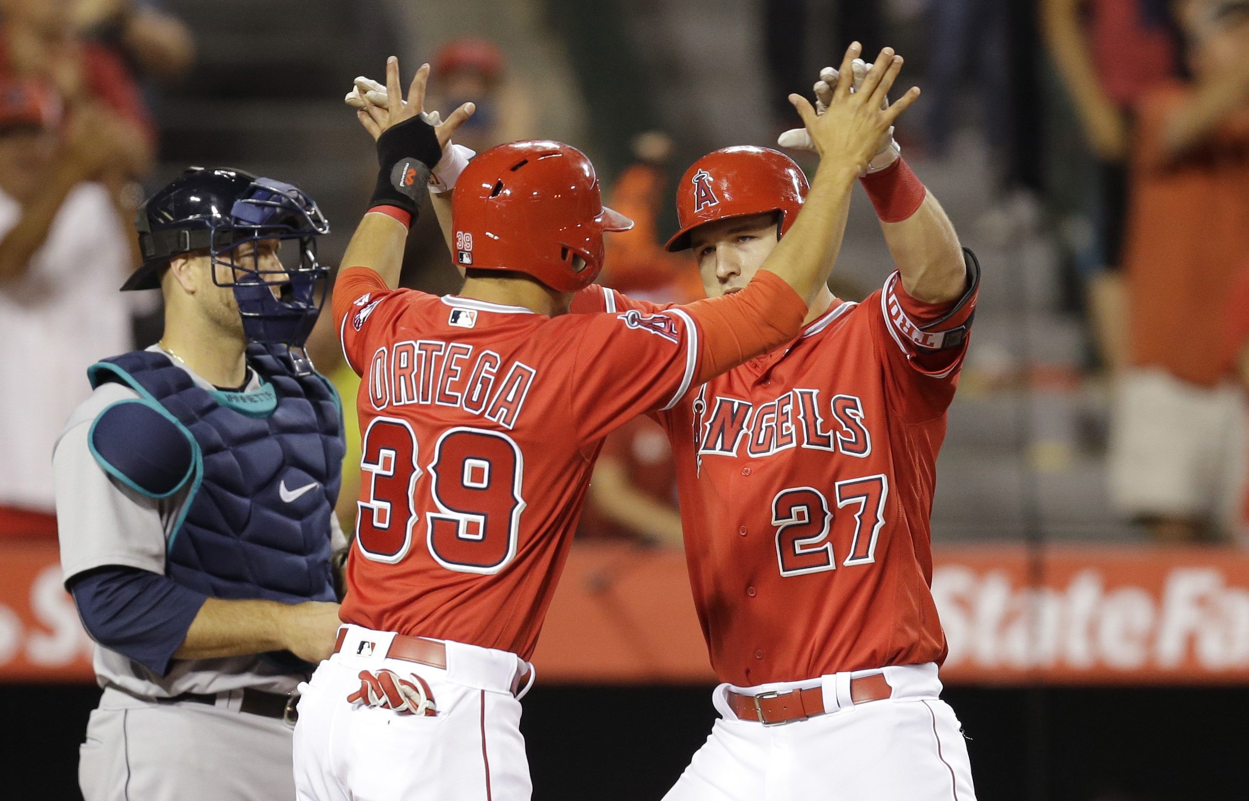 Los Angeles Angels' Mike Trout, right, celebrates his two-run home run with teammate Rafael Ortega during the sixth inning of a baseball game against the Seattle Mariners, Saturday, April 23, 2016, in Anaheim, Calif. (AP Photo/Jae C.