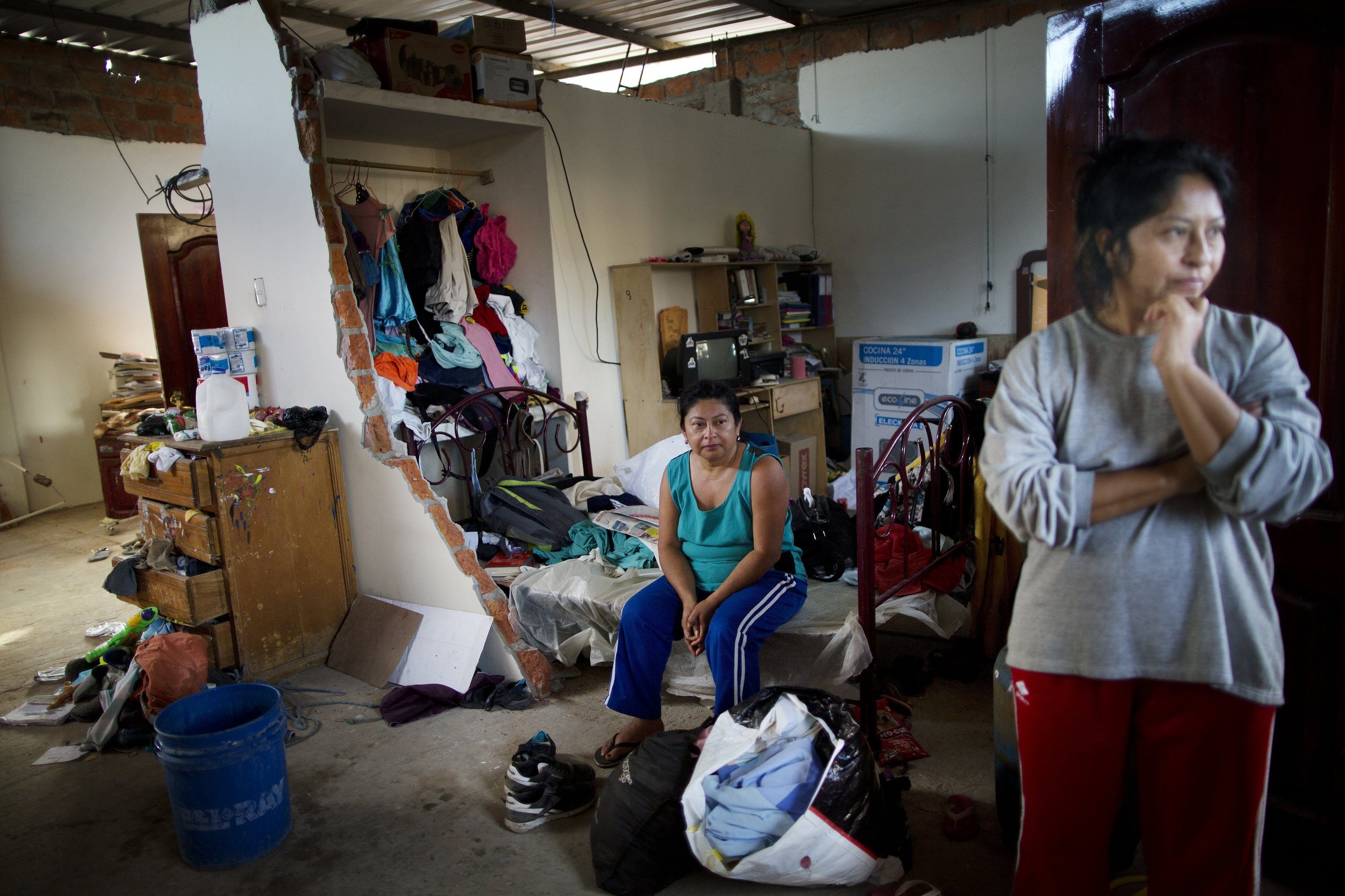 Miriam Vera sits inside her home that was severely damaged by the earthquake in Manta, Ecuador, Tuesday, April 19, 2016, after her family spent the night outside. The strongest earthquake to hit Ecuador in decades flattened buildings and buckled highways along its Pacific coast, sending the Andean nation into a state of emergency.