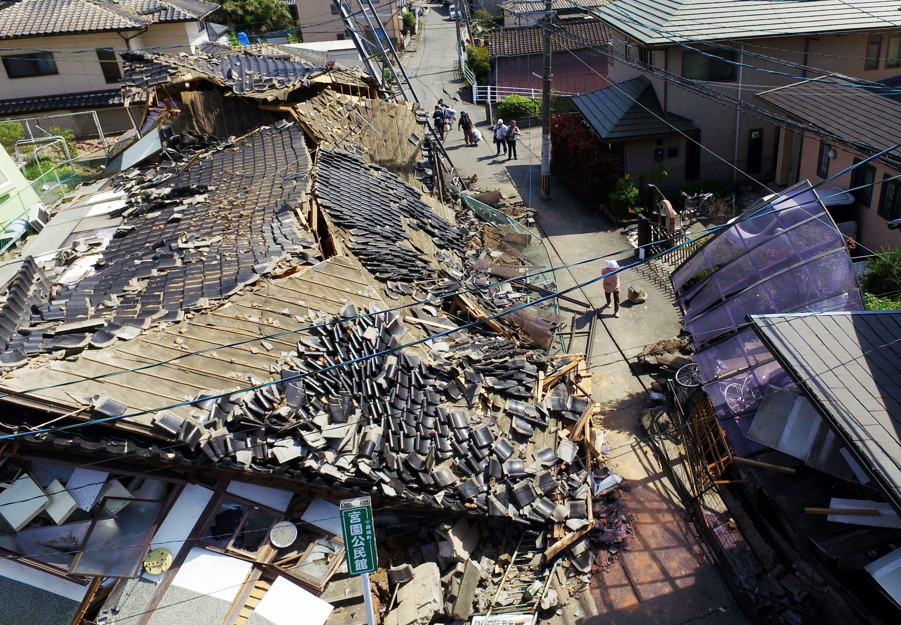 This aerial view shows damaged houses in Mashiki town, Kumamoto prefecture, southern Japan,  Friday, April 15, 2016, a day after a magnitude-6.5 earthquake. More than 100 aftershocks from Thursday night's magnitude-6.5 earthquake continued to rattle the region as businesses and residents got a fuller look at the widespread damage from the unusually strong quake, which also injured about 800 people.