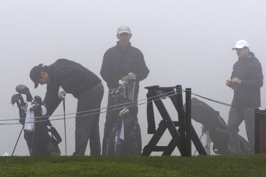 President Barack Obama, center, prepares to play golf in a thick fog Saturday at The Olympic Club in San Francisco.