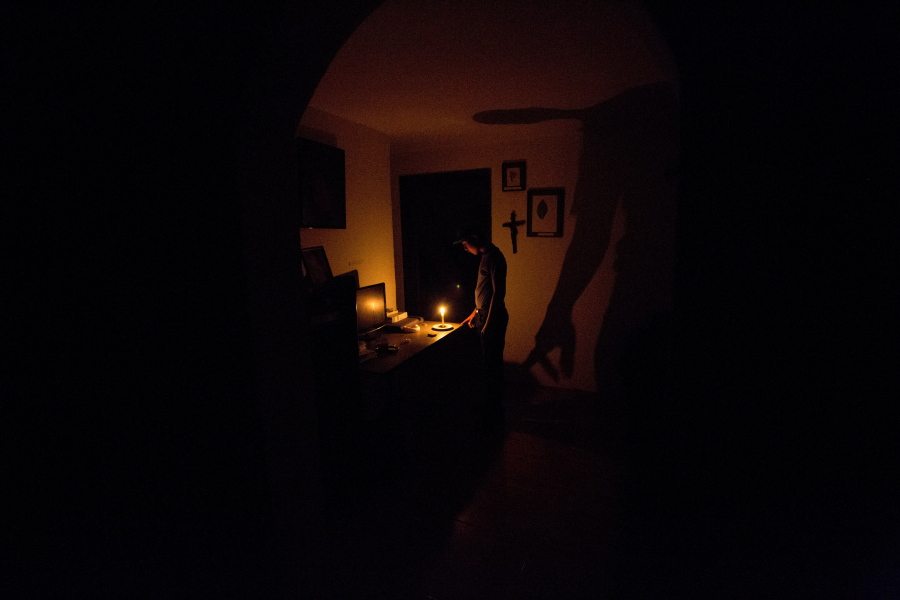 A boy illuminates his home with a candle during a 24-hour blackout Saturday in the El Calvario neighborhood of El Hatillo, just outside of Caracas, Venezuela.