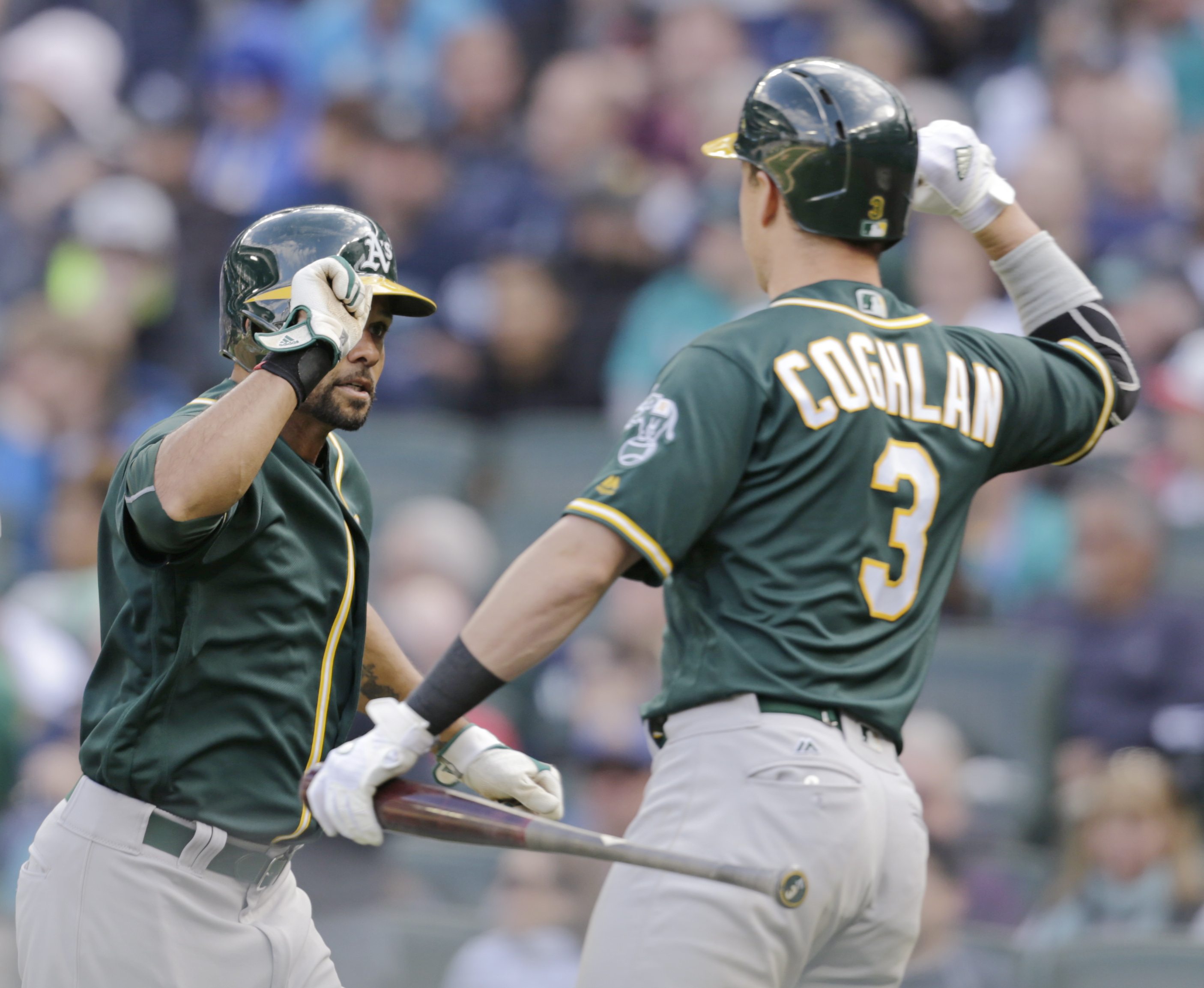 Oakland Athletics' Coco Crisp, left, is congratulated at home by Chris Coghlan after hitting a solo home run on a pitch from Seattle Mariners' Nick Vincent during the 10th inning of a baseball game, Sunday, April 10, 2016, in Seattle. The Athletics won 2-1.