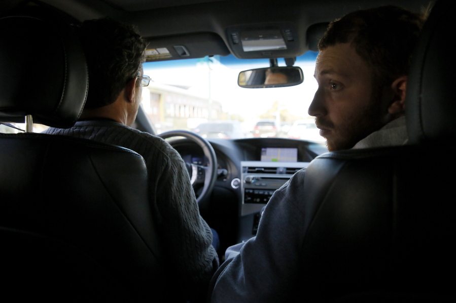 In this Wednesday, March 2, 2016 photo, Sam Alexander drives his son, Ben, back home following a class at Tulane University in New Orleans. Alexander, who has nonverbal autism, is a junior at Tulane, an English major with a 3.7 GPA and a computer full of essays, one of them published in a local journal and another on the university?s news site.